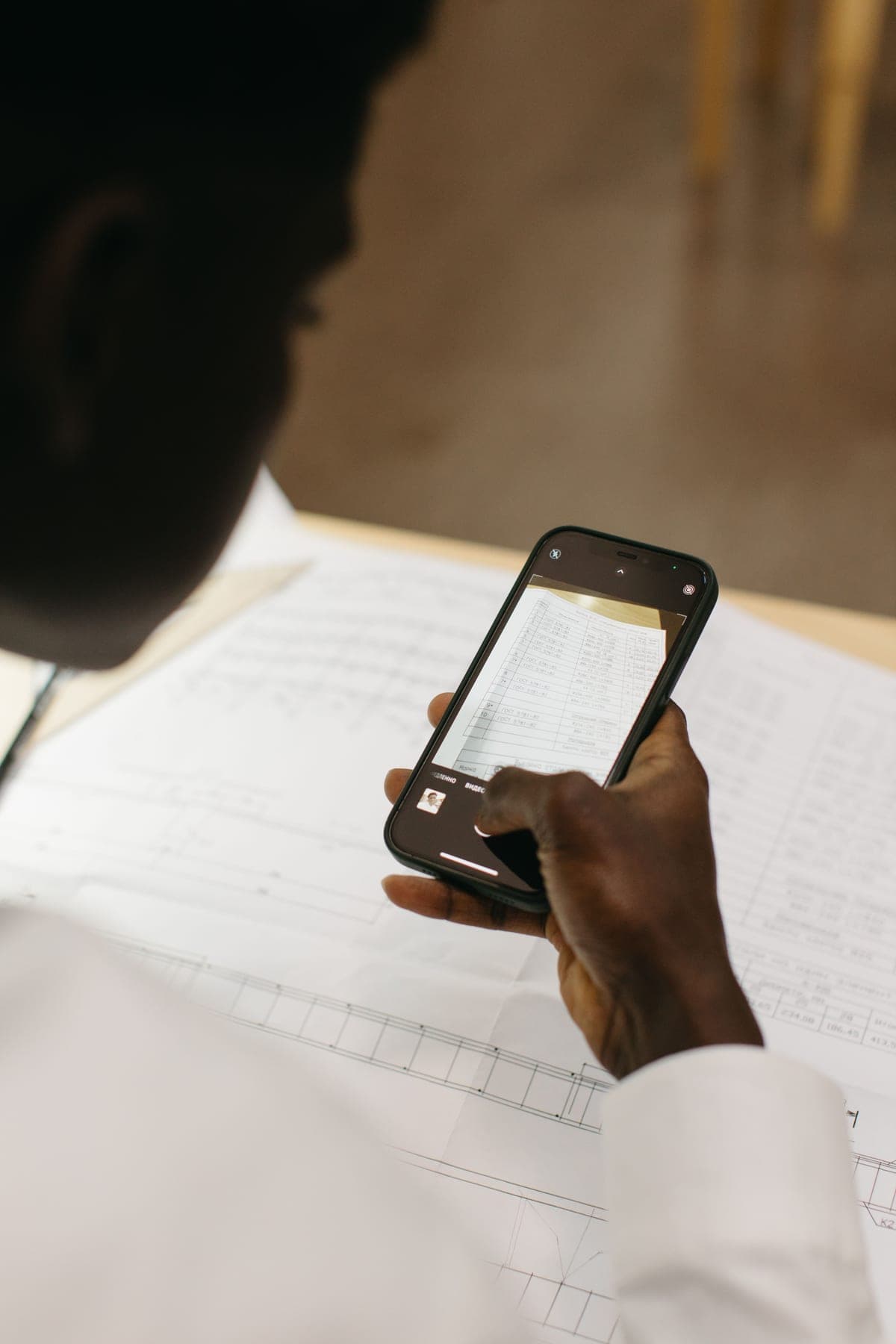 Student photographing a printed question paper with a smartphone